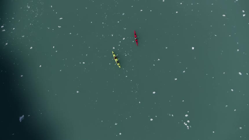 Kayaks sailing on ice covered lake