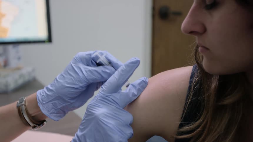 A patient is being given a shot in the arm