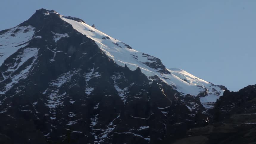 A snow covered mountain peak against a blue sky