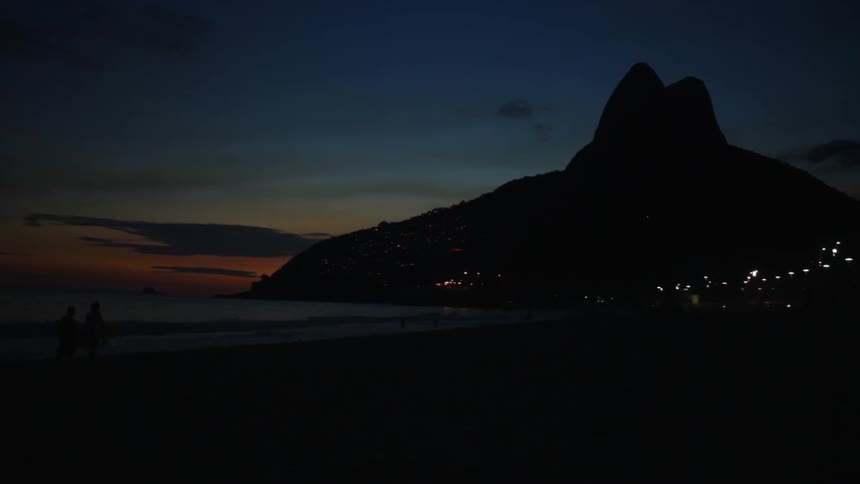 People walking along a beach at night