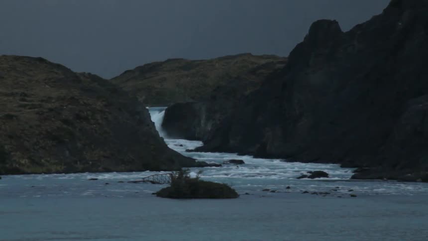 A stream leads to a waterfall in the distance