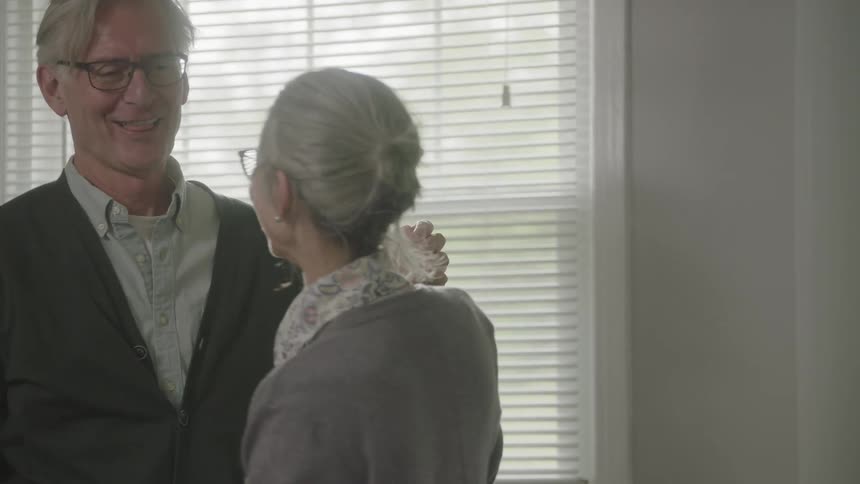 Elderly couple dances and enjoys themselves at home