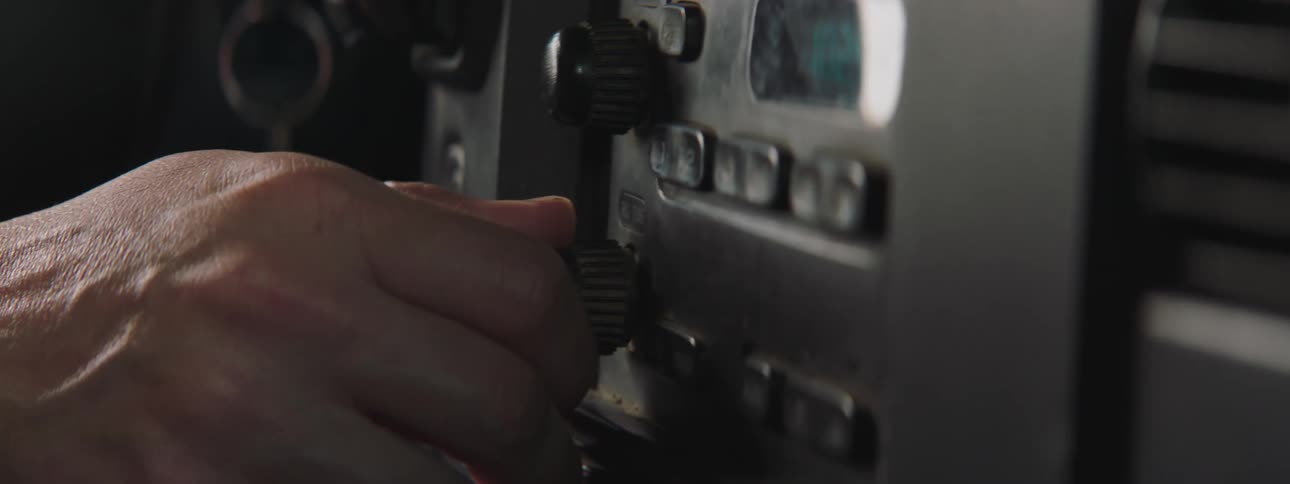 A man turns a dial on a car radio