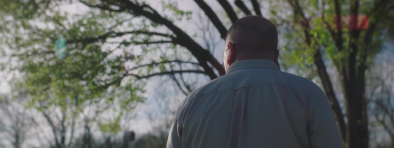 Bald man standing outside looking confused