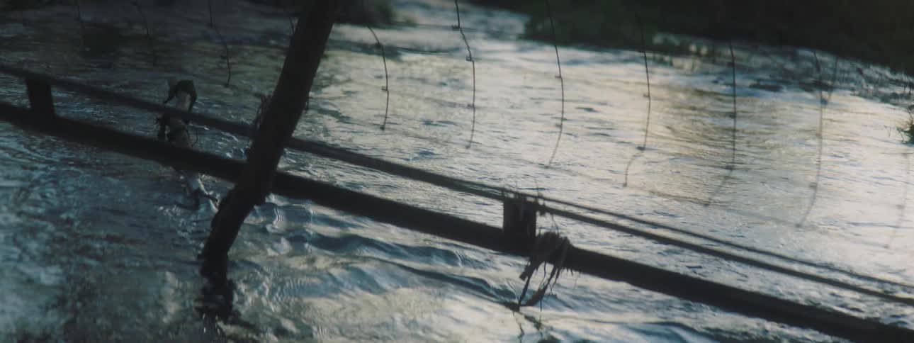 A stream flows below a metal net