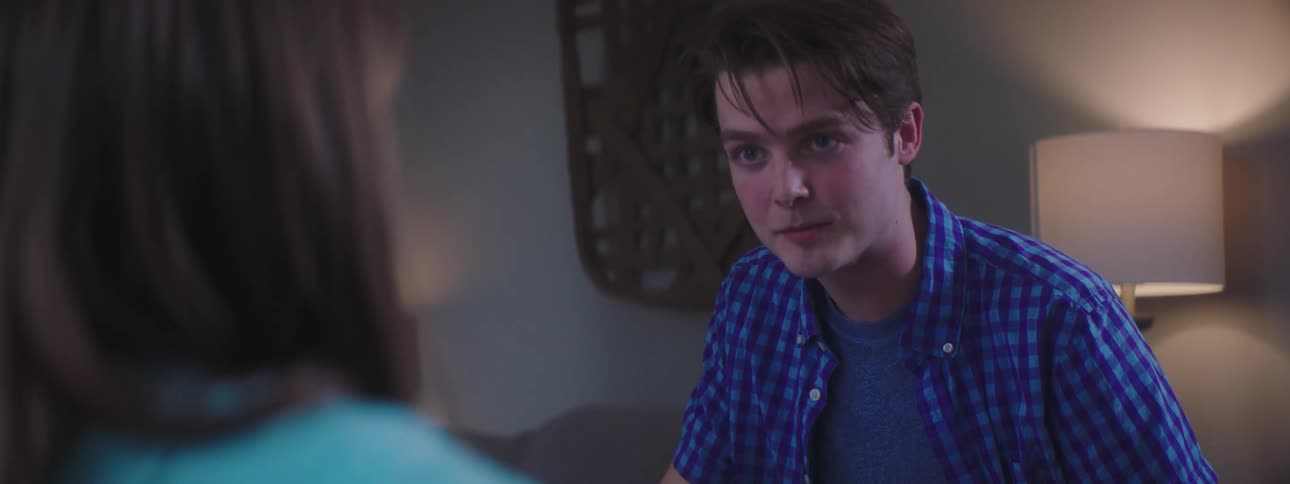 A teenage boy and girl sit at a table and color together