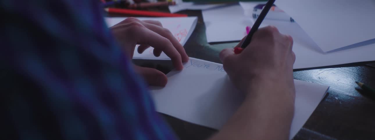 Man writing note on paper with pencil