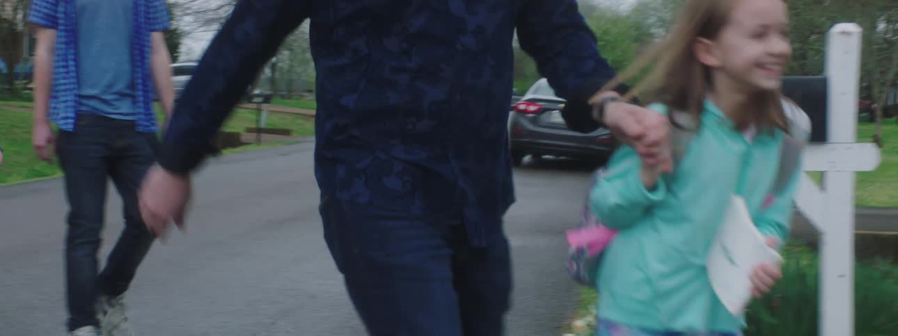 Daughter tugs father toward house as the others smile and laugh