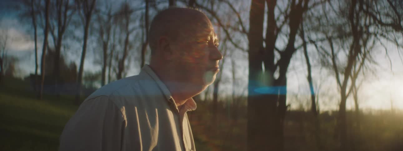 Elderly man crying in sadness outdoors in a forest area
