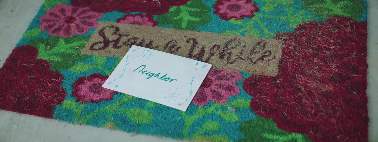 An envelope being dropped on a neighbors door mat