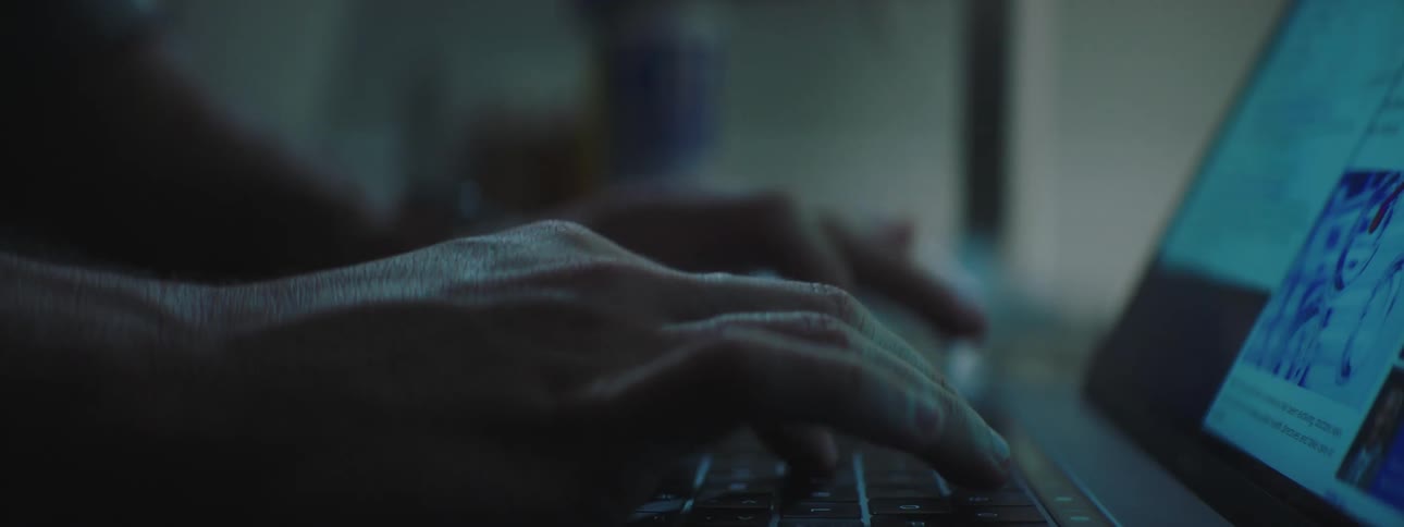 Hands typing on laptop keyboard