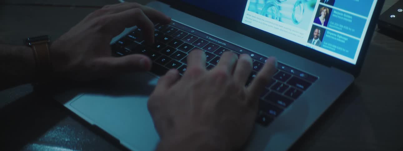 Man typing on the keyboard of a laptop