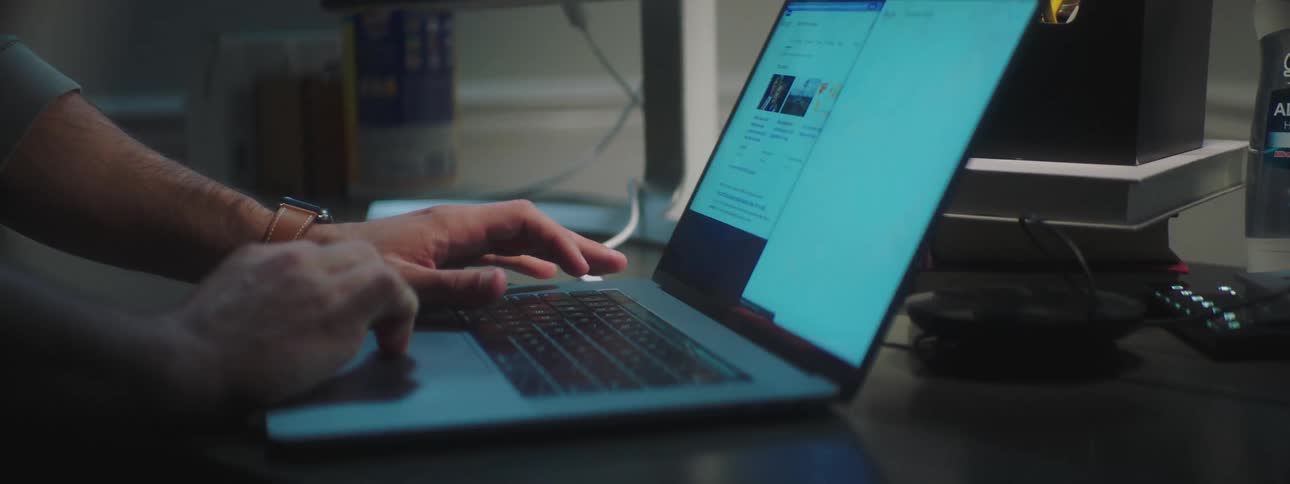 Man sitting at the desk uses a laptop at home