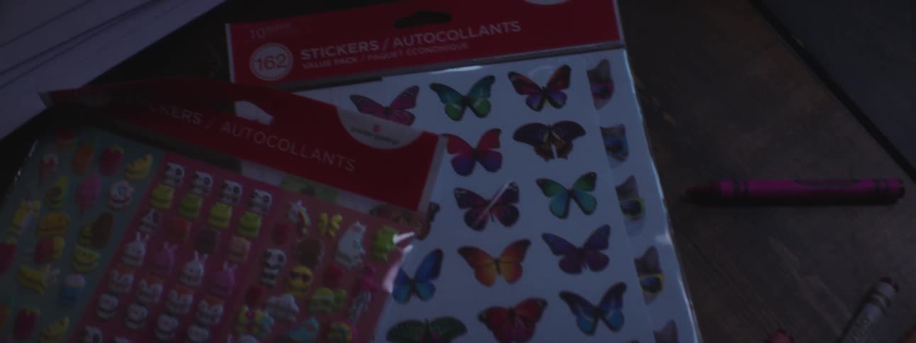 Stickers and crayons lay on wooden table near thank you cards