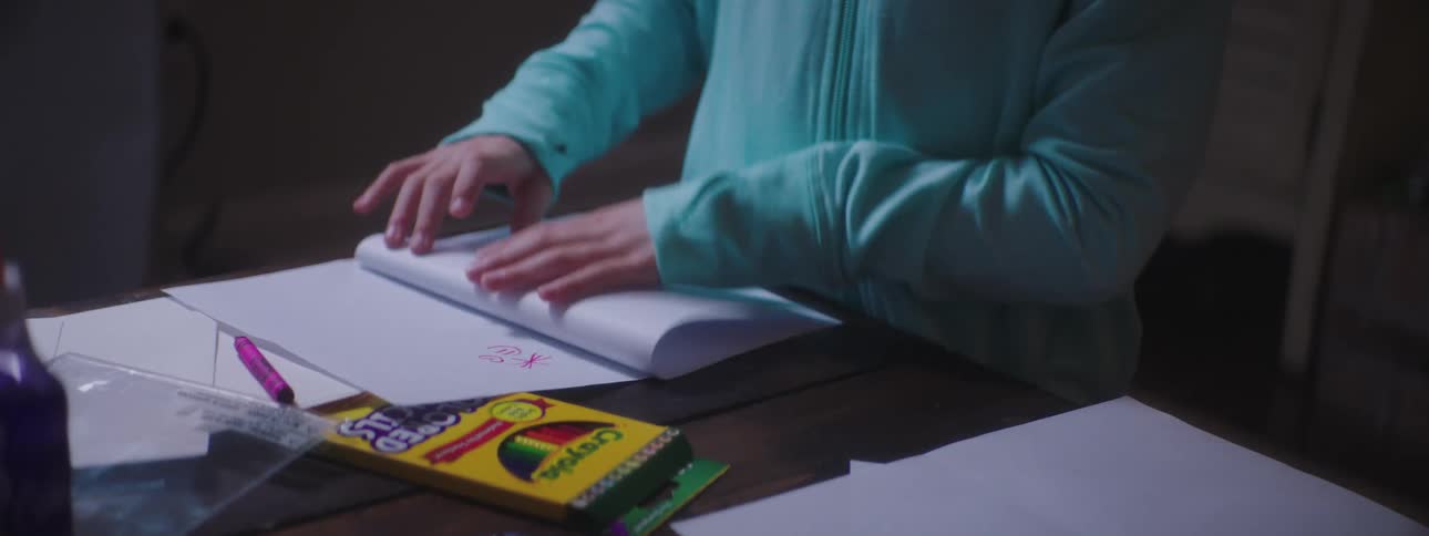 A young girl folds pieces of paper in half