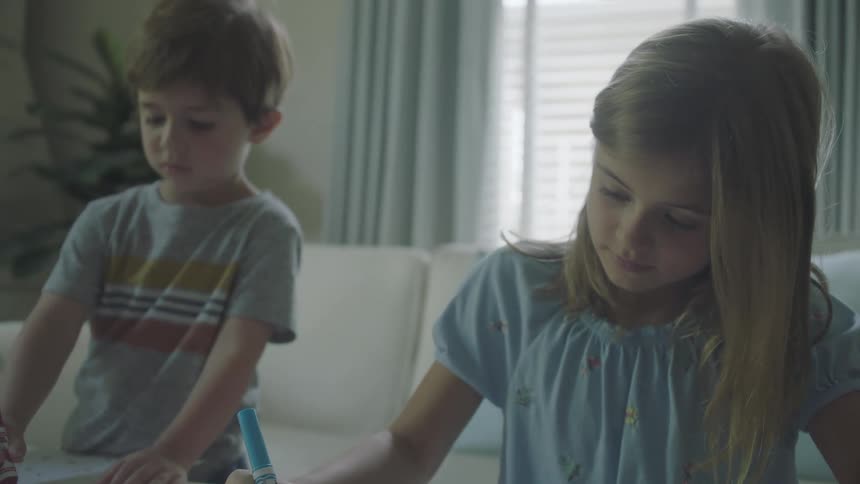 Children drawing with markers in the living room