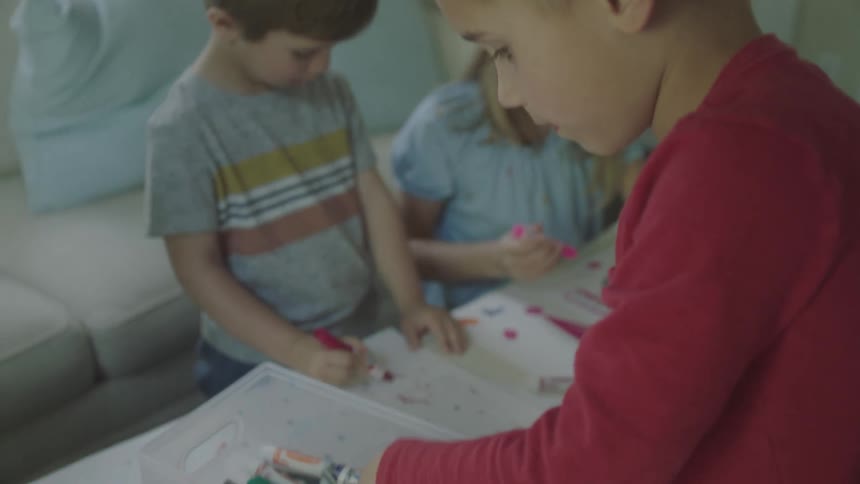 Children hanging out creating posters on a coffee table