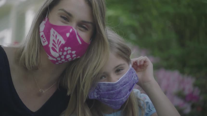 Mother and daughter wearing face masks while outdoors during the pandemic