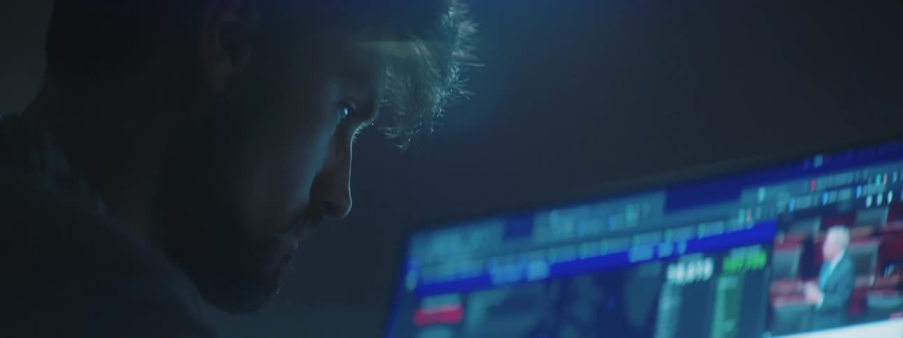 Man sits in front of monitor showing video among other windows