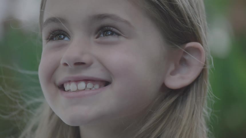 A portrait of a little girl positively beaming with pleasure