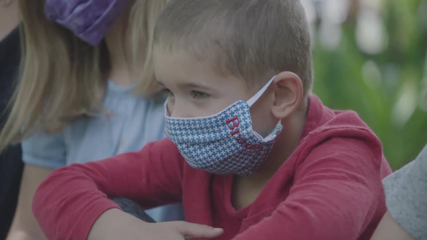 A mother and her children wear masks while outside