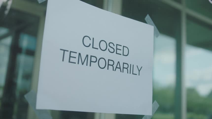 Sign in store door reads closed temporarily