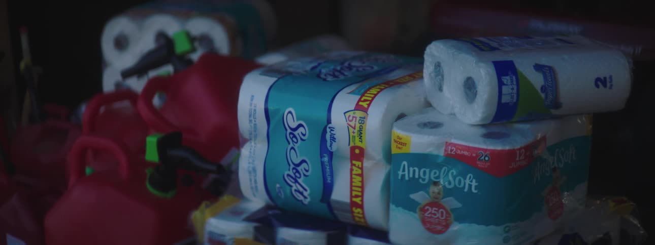 A pile with gas cans toilet paper and paper towels