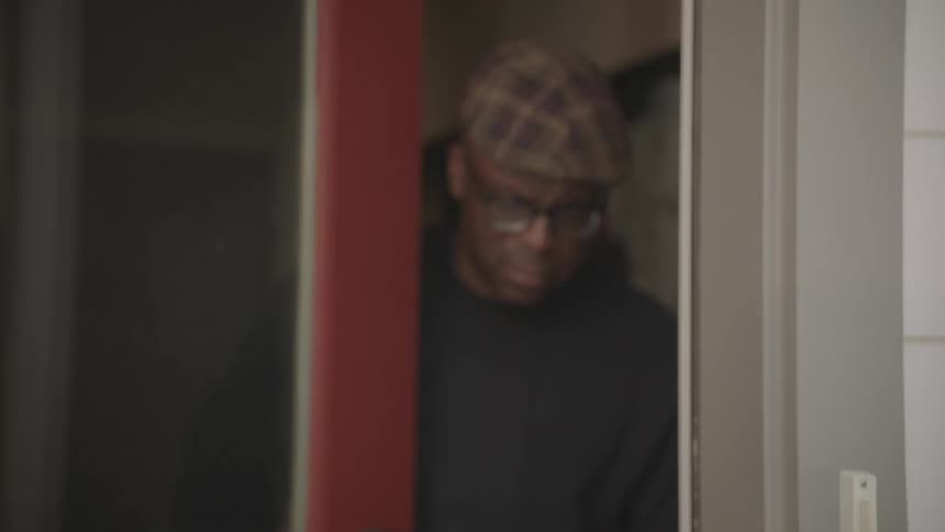 Elderly man opens door to pick up recently delivered groceries
