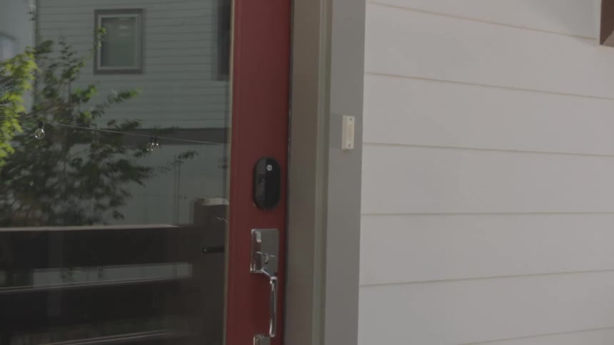A man waves at a young woman who left a box of food in front of his door