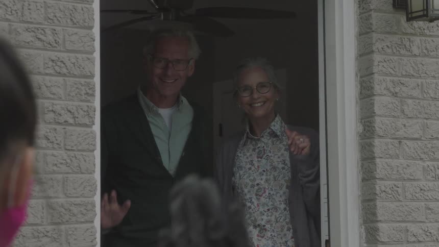 Elderly couple opens door to receive delivered groceries