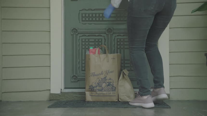 Woman leaves food bags on the doorstep during lockdown