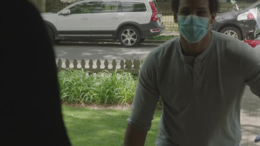 People wave to one another as a man delivers paper products to someone