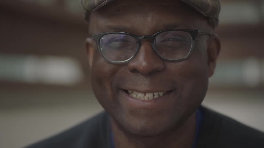 A black man raises his head and smiles with pleasure