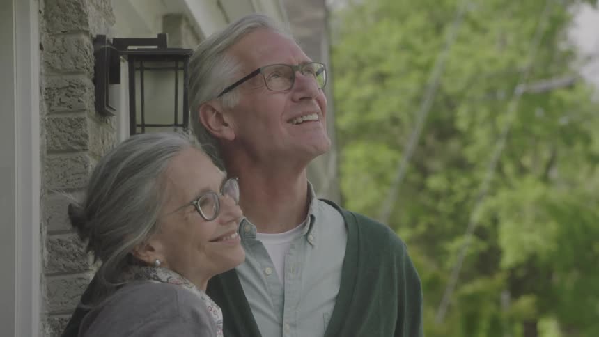 Elderly couple walks outside house and relax