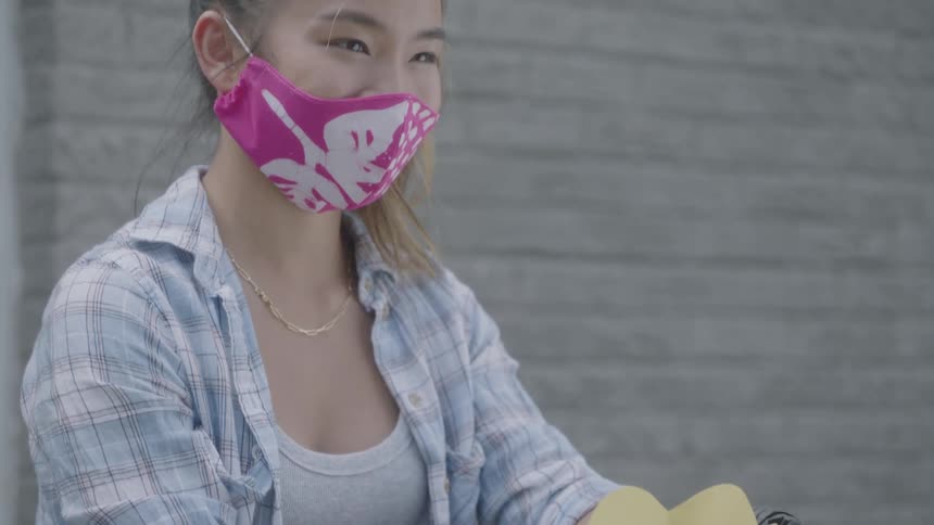 A teenager holds a bag with a big heart on it