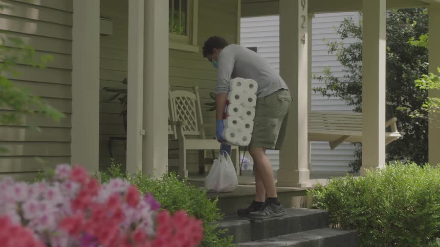 Man delivering groceries leaves groceries on the porch