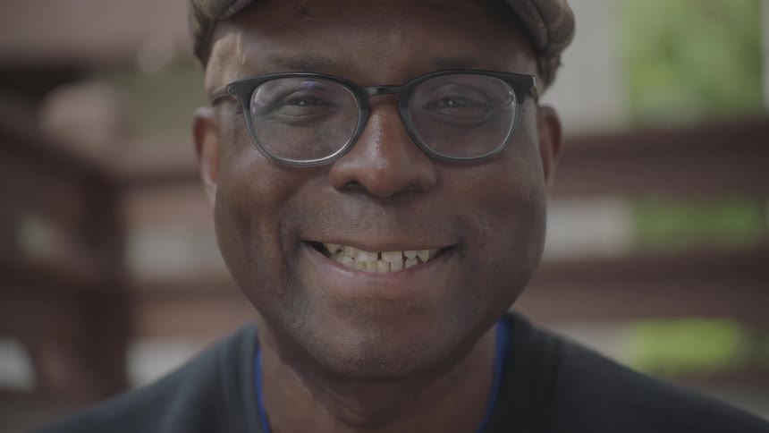 Elderly man turns around and looks at camera smiling