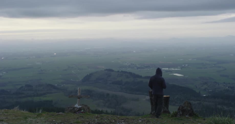 Man watches the horizon on top of a mountain