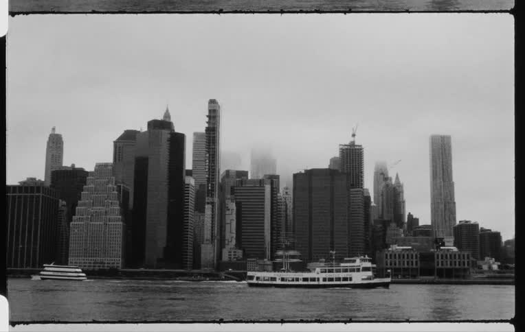A ferry and boats travel past a city skyline
