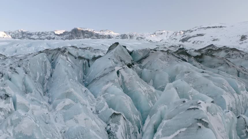 Snow covered mountains sit under a blue sky