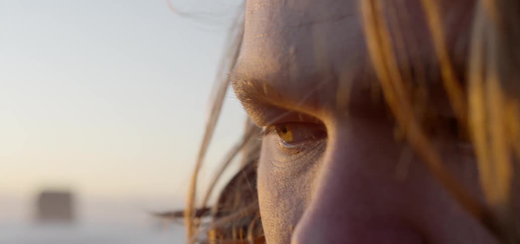 Close up of long haired mans face standing on the beach