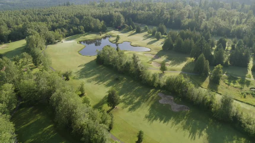 Forest and mountains surround valley containing golf course