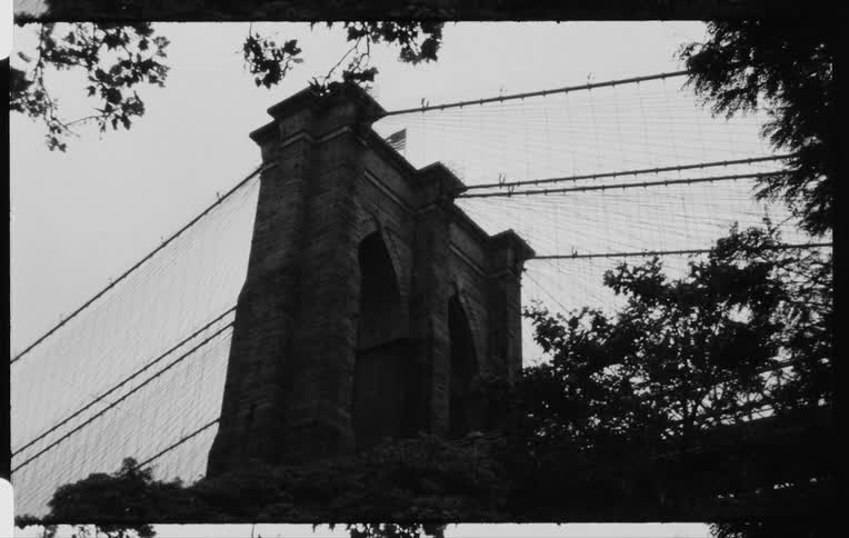 Old film of a large bridge aiming at the sky