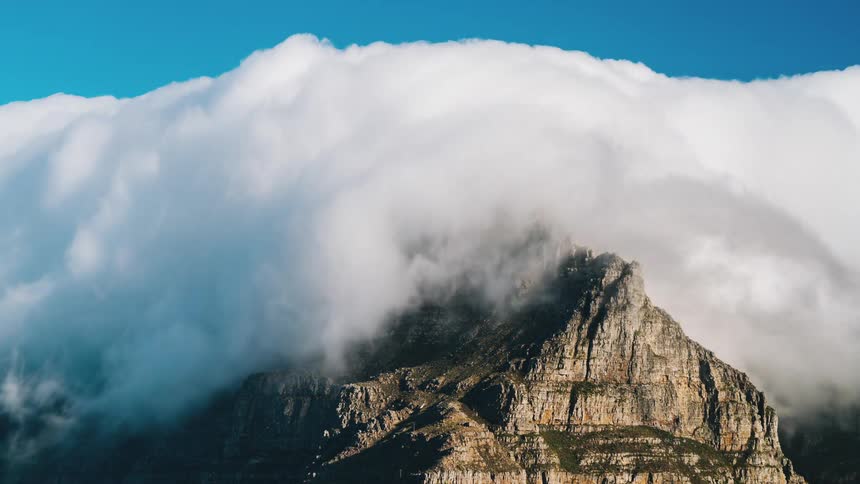 Dense white clouds float over the mountains