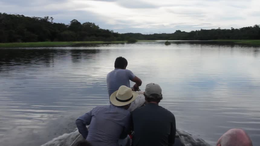 People are sitting in a boat as it travels on a cloudy day