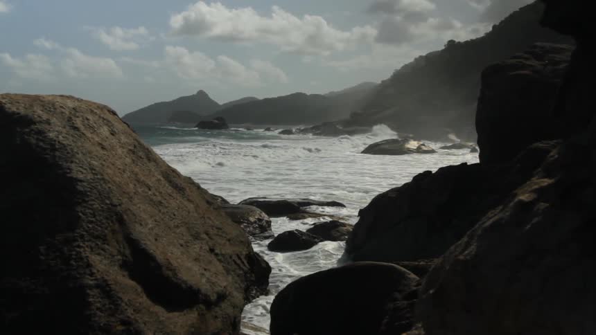 Ocean waves crash ashore a rocky beach