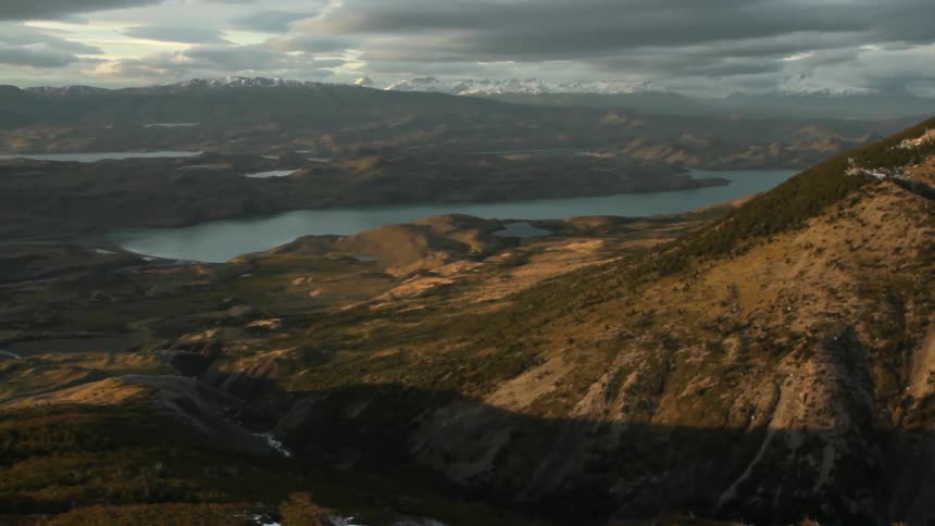 A mountain lake is shown on a cloudy day