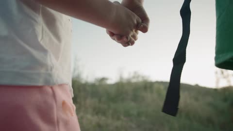 Two children walk hand and hand