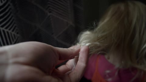A mother reaches down and touches her daughters hair
