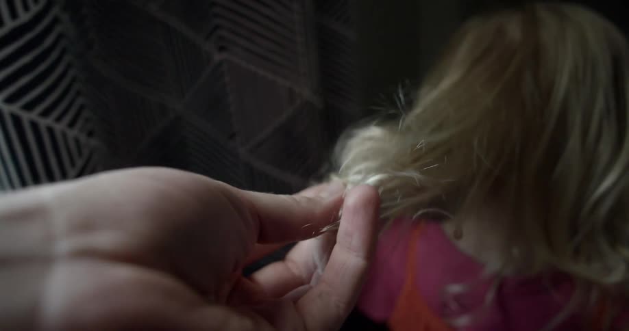 A mother reaches down and touches her daughters hair